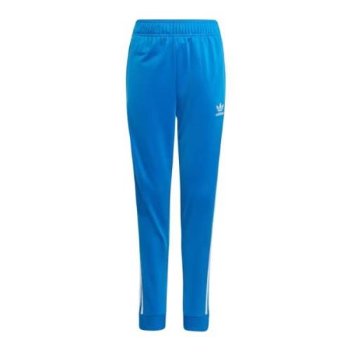 Adidas Originals Ljusblåa träningsbyxor med ikoniska ränder Blue, Unis...